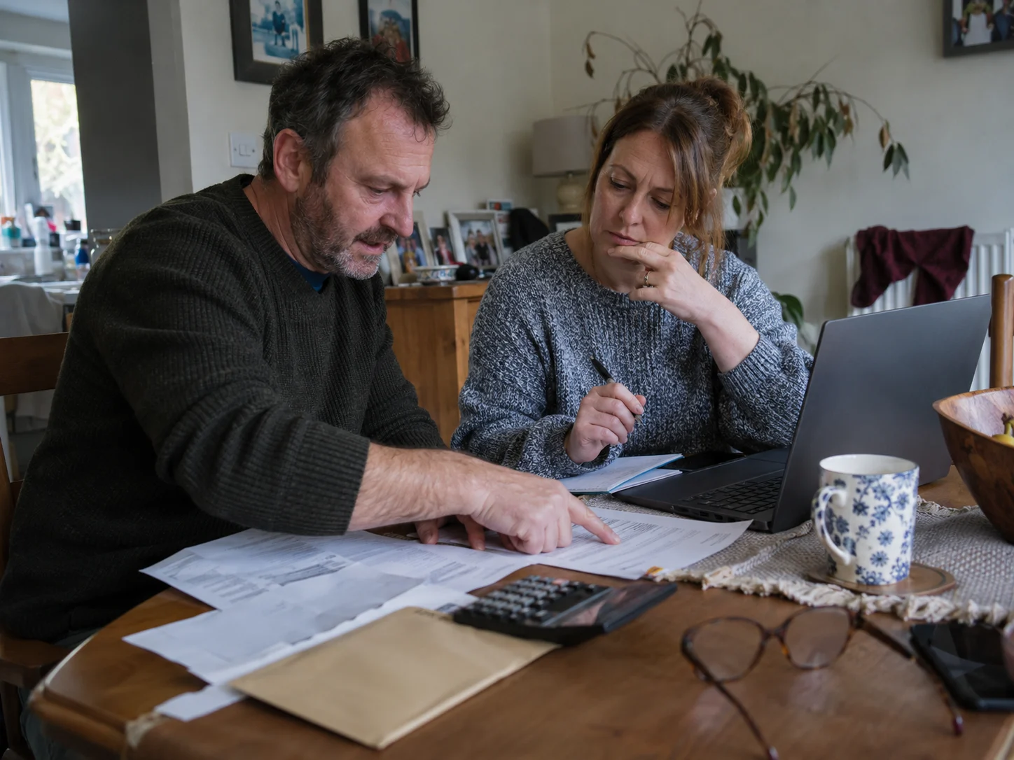 A couple at their dining table going through their car finance paperwork